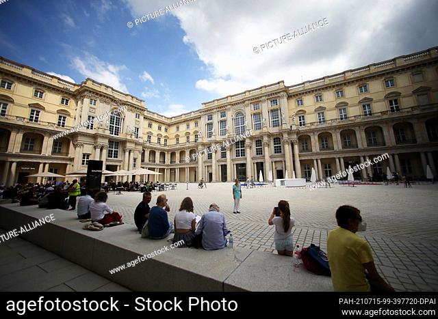 15 July 2021, Berlin: People sitting in the Schlüterhof of the Humboldt Forum. The rebuilt Berlin City Palace opens on July 20 with several exhibitions