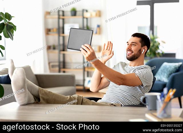 man with tablet pc having video call at home