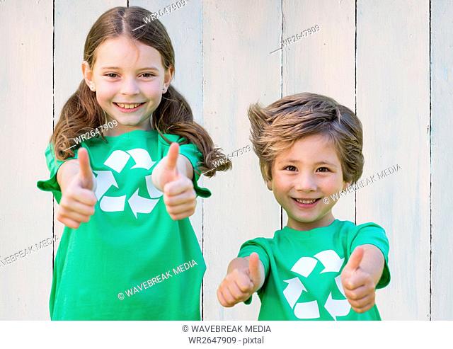 Two smiling children showing thumbs up