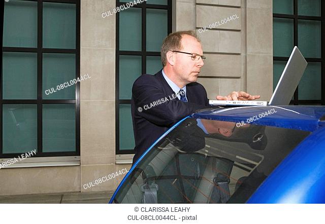 Man using laptop on car