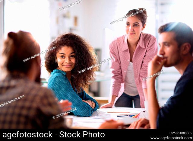 meeting at the startup office. A young woman leads a multi-ethnic working group