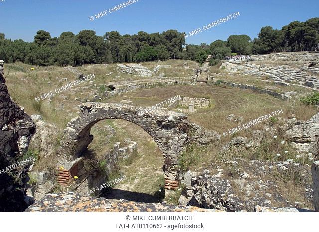 Archaeological site. Roman amphitheatre. 3rd century AD. Semi-circle of steps around flat stage. Arch