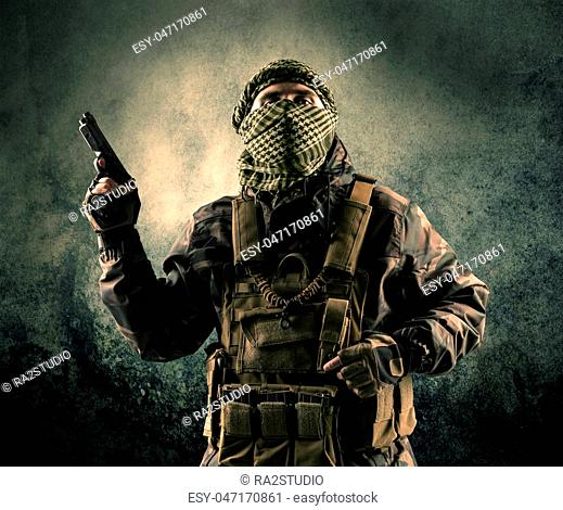 Portrait of a heavily armed masked soldier with grungy background concept