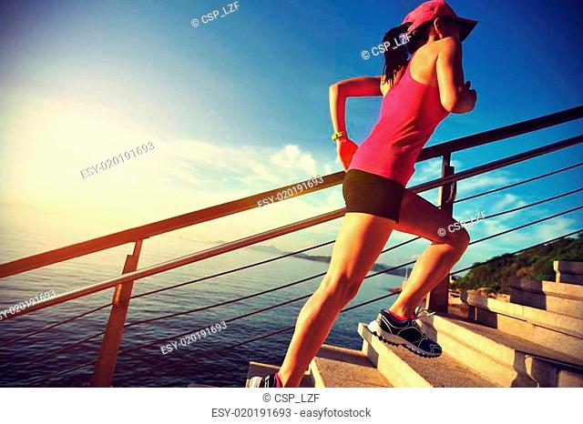 healthy lifestyle sports woman running up on stone stairs seaside