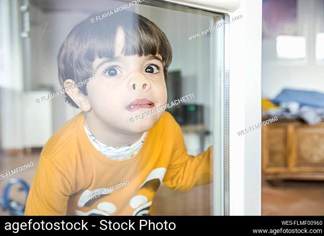 Boy pressing nose against window