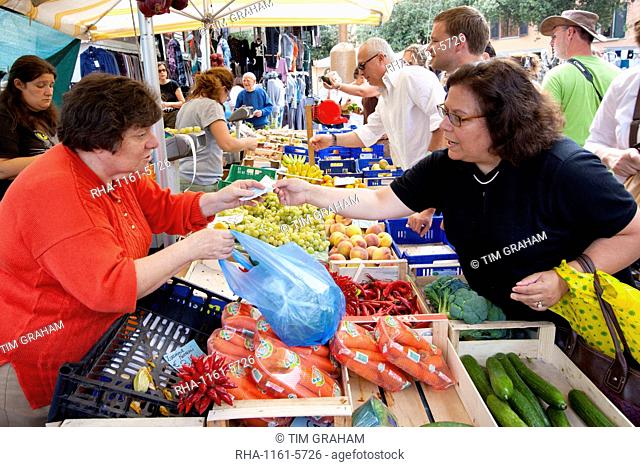 Woman selling fresh fruit at weekly street market in Panzano-in-Chianti, Tuscany, Italy