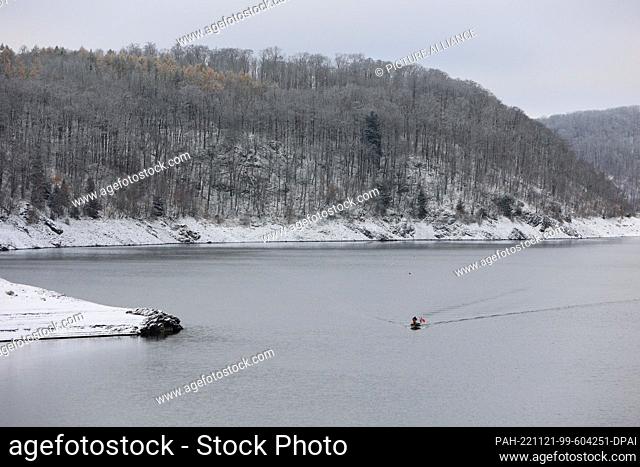 21 November 2022, Saxony-Anhalt, Thale: Two professional fishermen sail across the Rappbode Dam in a boat. They set their nets to fish the dwarf whitefish out...