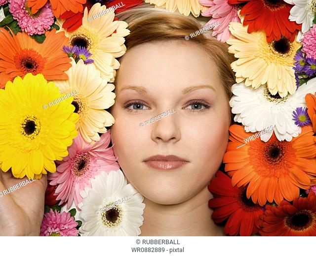Portrait of a young woman lying on flowers