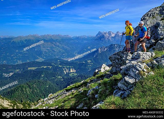 Italy, Province of Belluno, ¶ÿPair of hikers admiring views along Alta Via Dolomiti Bellunesi trail