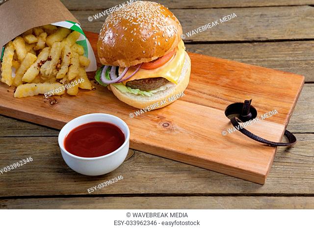 Hamburger, french fries and tomato sauce on table