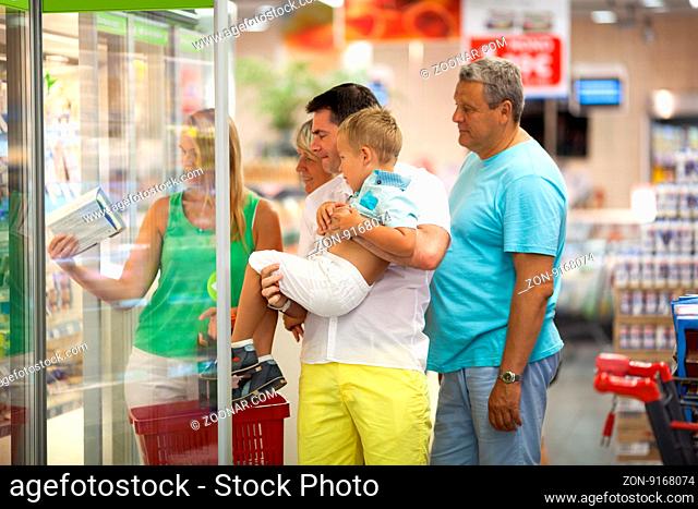Big family with kid choosing food in supermarket