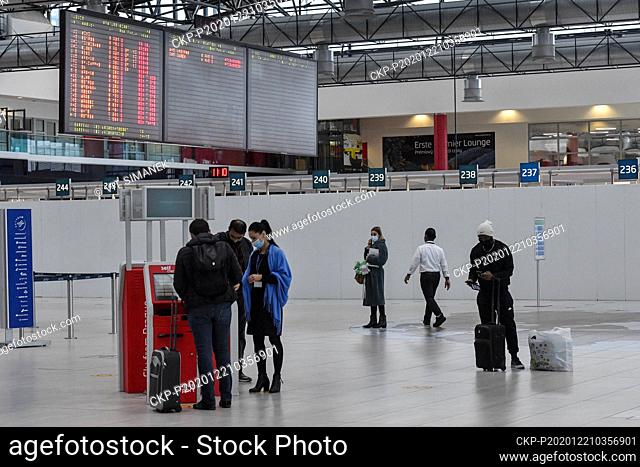 Passengers in protective face masks against the spread of coronavirus are seen on December 21, 2020, in the departure hall of Vaclav Havel Airport Prague