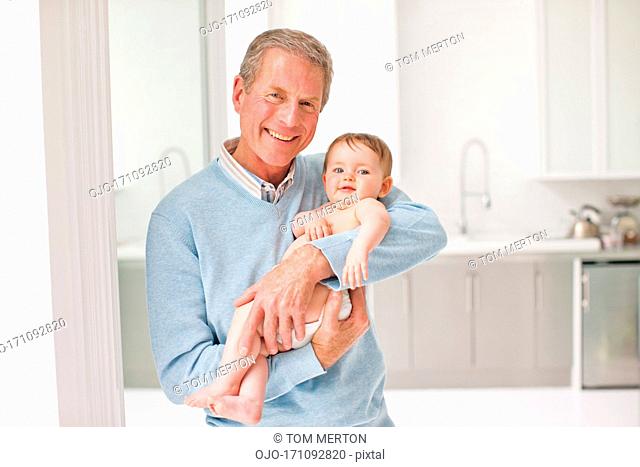 Smiling grandfather holding baby