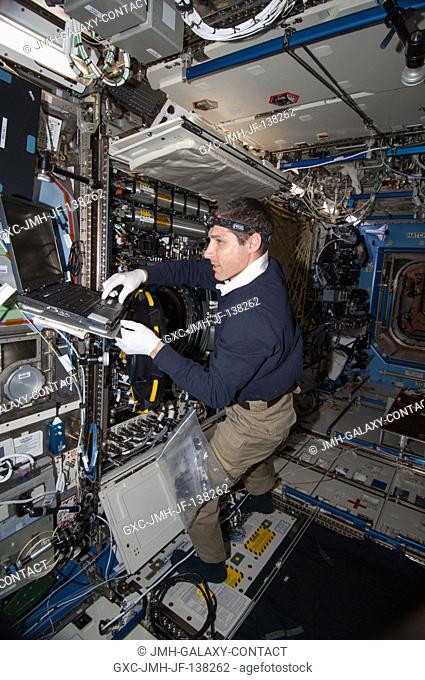 NASA astronaut Mike Hopkins, Expedition 38 flight engineer, performs in-flight maintenance on combustion research hardware in the Destiny laboratory of the...