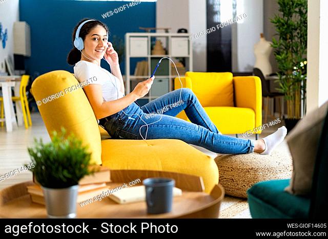 Young woman listening music relaxing on sofa at home