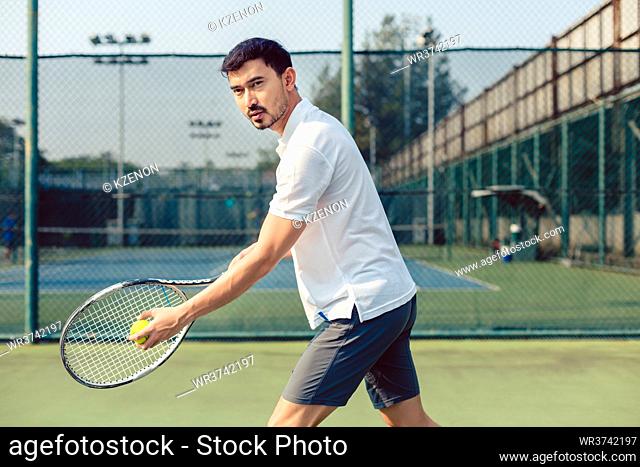Portrait of determined tennis player looking forward with concentration before serving during a challenging match