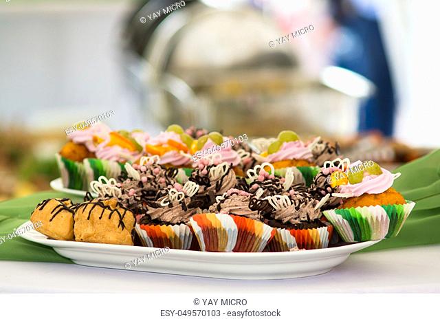 Cupcakes colored wrappers on a plate standing on the table