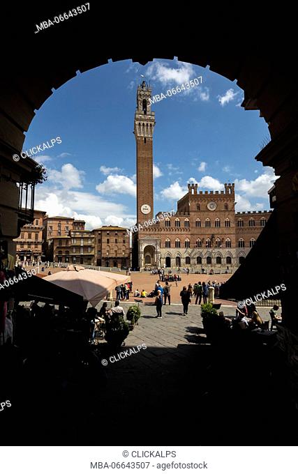 The old arch frames the the historical Palazzo Pubblico and its Torre del Mangia Piazza Del Campo Siena Tuscany Italy Europe