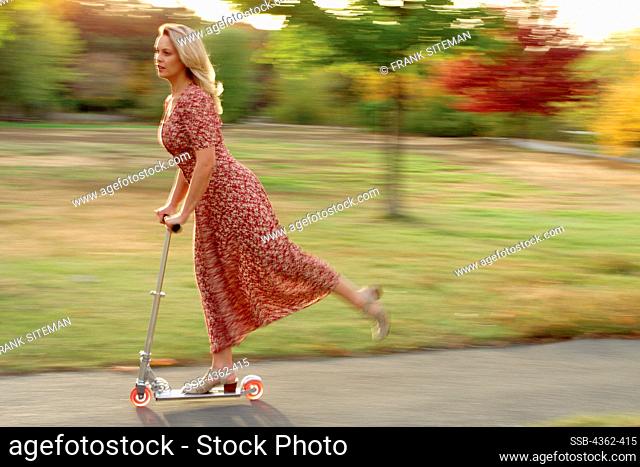 Young Woman Rides Scooter in the Summer