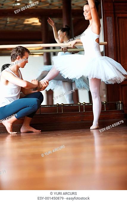 Portrait of a male ballet trainer training a female ballet dancer