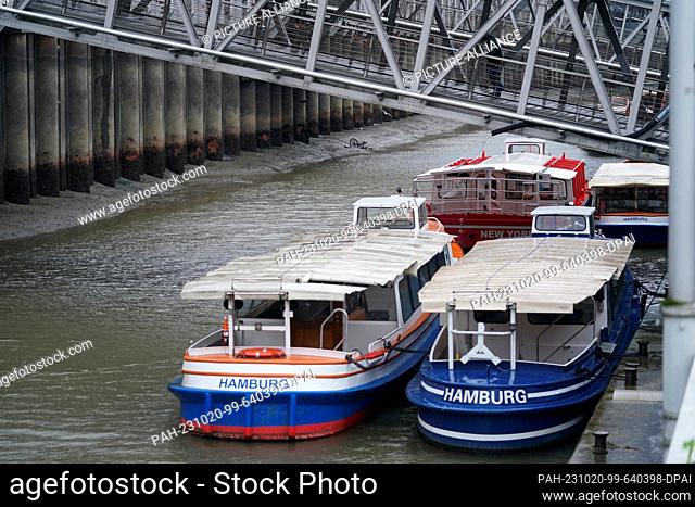 20 October 2023, Hamburg: Sandbanks (l) and a bicycle (behind) on the bottom of the Elbe are seen at low water at the Landungsbrücken in the harbor