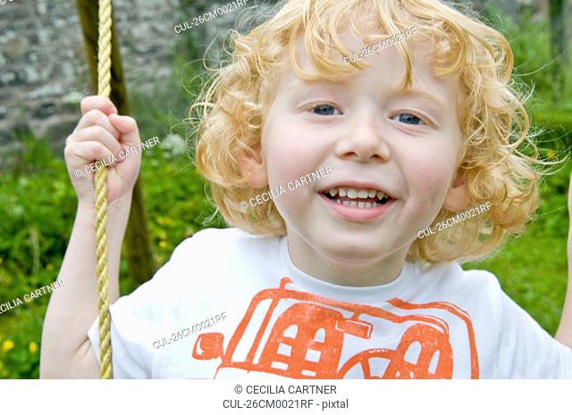 Boy smiling on swing