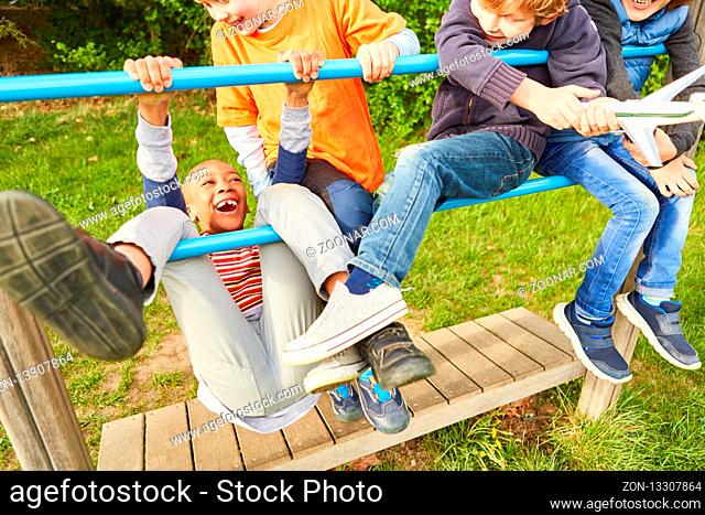 Gruppe Kinder hat Spaß beim Klettern und Spielen auf einem Klettergerüst im Park