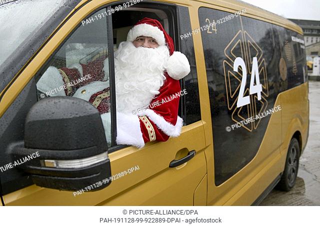 28 November 2019, Hamburg: A driver of the shuttle service ""Moia"" disguised as a Christmas man sits on the driver's seat of one of the vehicles