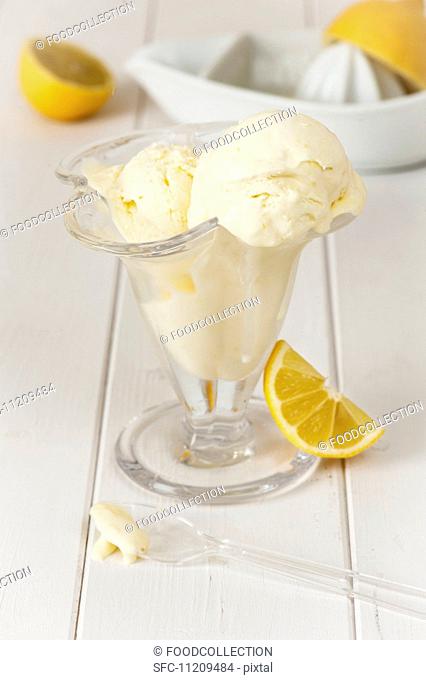 lemon ice cream in a glass dish with fresh lemons