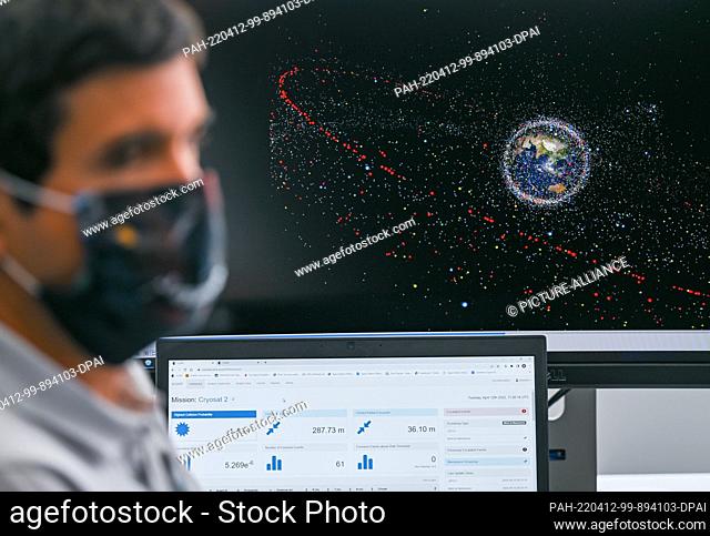 12 April 2022, Hessen, Darmstadt: An engineer sits in front of a monitor showing an animation of space debris at the European Space Agency's (ESA) new Space...