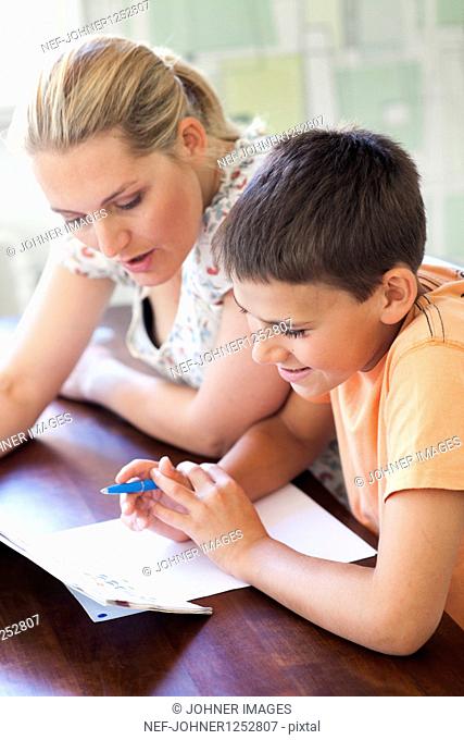 A man helping her son with hes homework