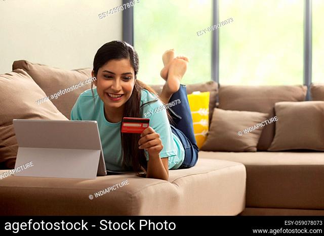 A girl with laptop and credit card shopping online
