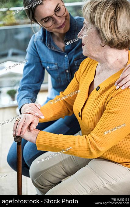 Senior woman talking with caregiver at home