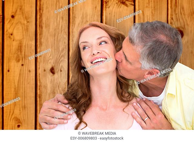 Composite image of man giving his partner a kiss