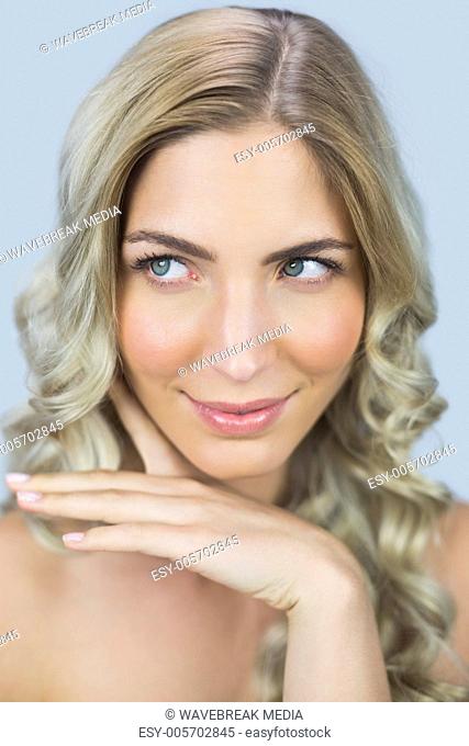 Pensive natural blonde posing touching her face