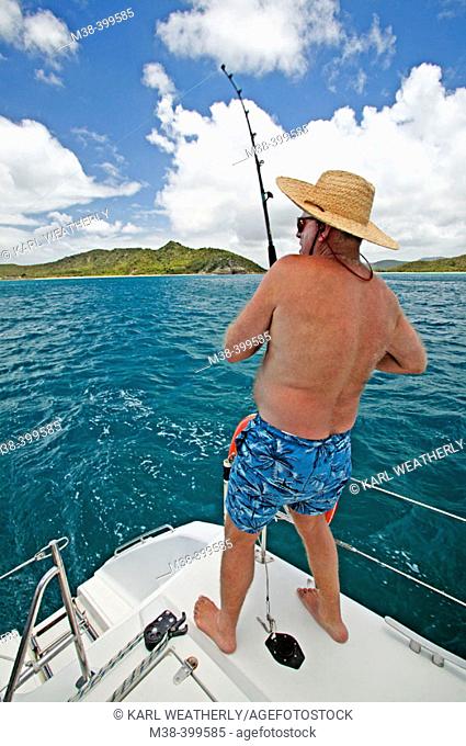 Man fishing off the back of a catamaran while sailing in Antigua