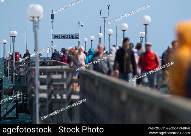 31 May 2020, Mecklenburg-Western Pomerania, Binz: ourists walk across the pier. Lively north-easterly wind has brought joy to surfers and kite surfers