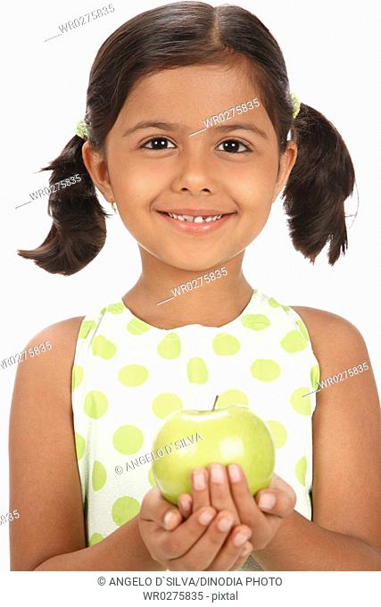 Eight year old girl holding green apple in both hands MR703U