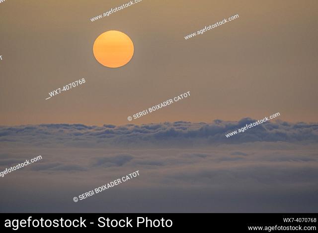 Winter sunrise with haze, fog and a sea of clouds, seen from Mont Caro (Tarragona, Catalonia, Spain)