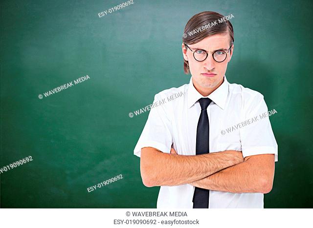Composite image of geeky businessman looking at camera with arms crossed