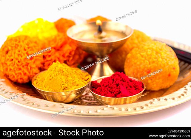 Beautifully Decorated Pooja Thali for festival celebration to worship, haldi or turmeric powder and kumkum, flowers, scented sticks in brass plate