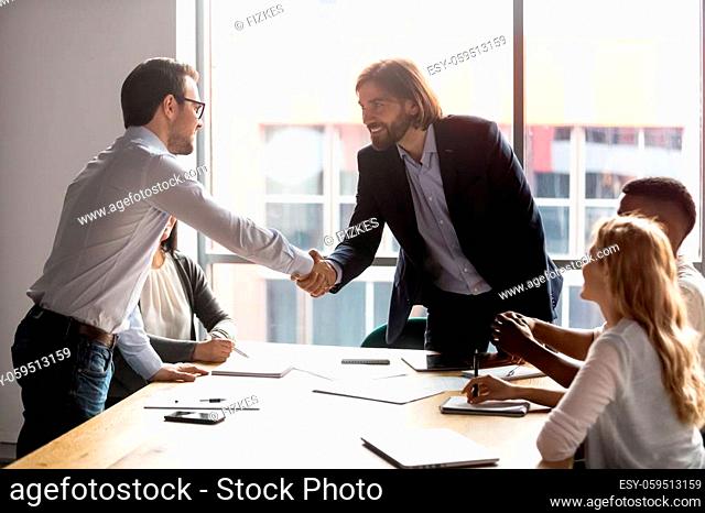Negotiation starts with businessmen leaders of business parties shake hands, boss greeting company client diverse businesspeople gathered together in modern...