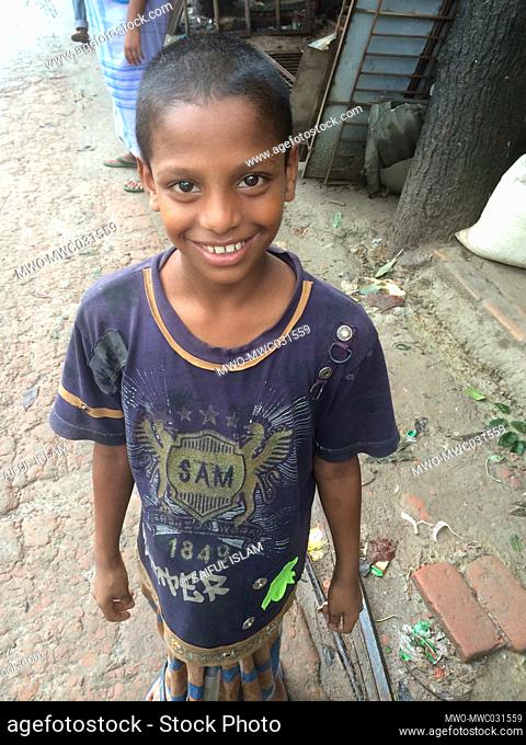 Boy, working as a helper in an iron rod selling shop, beams a smile for the benefit of the camera in Gazipur, Bangladesh