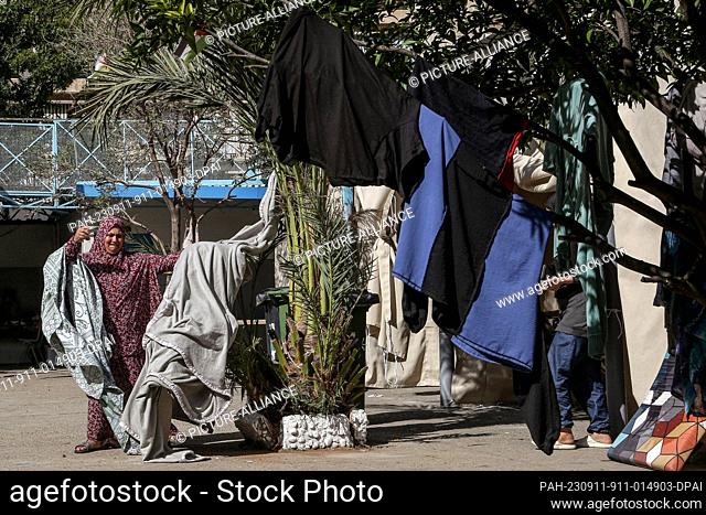 11 September 2023, Lebanon, Sidon: A Palestinian refugee hangs her laundry on a tree inside a United Nations Relief and Works Agency (UNRWA) school in the...