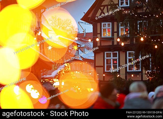 02 December 2023, Saxony-Anhalt, Quedlinburg: Visitors stand at the Christmas market in the Advent town of Quedlinburg. Advent in the courtyards has been around...
