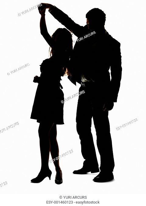 Portrait of a sweet young couple dancing together against white background