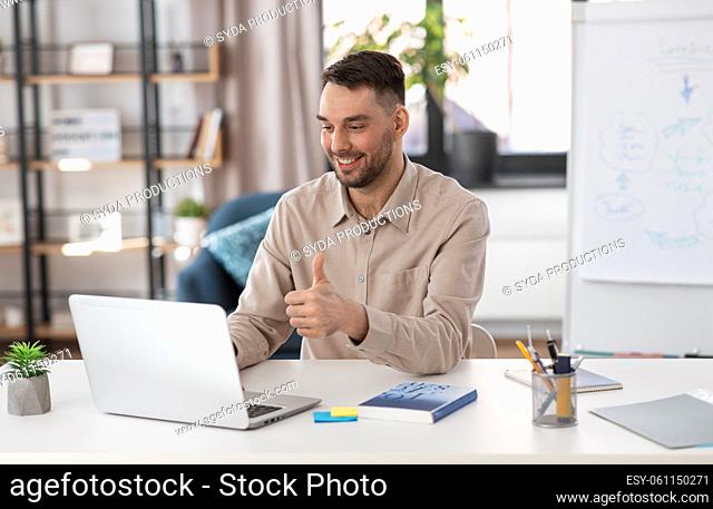 teacher with laptop having online class at home