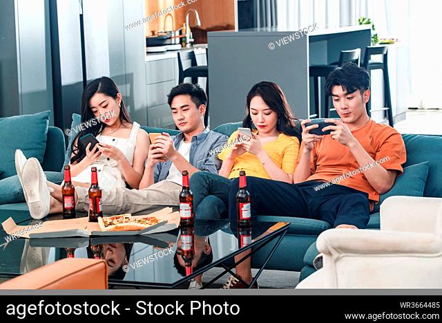 Young friends on the couch watching a mobile phone