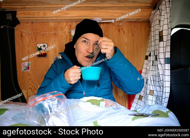 Woman eating in camper van