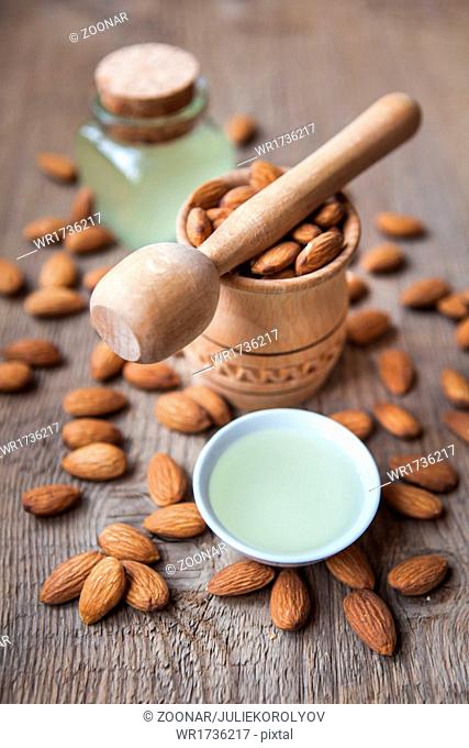 almonds oil and nuts on a wooden background